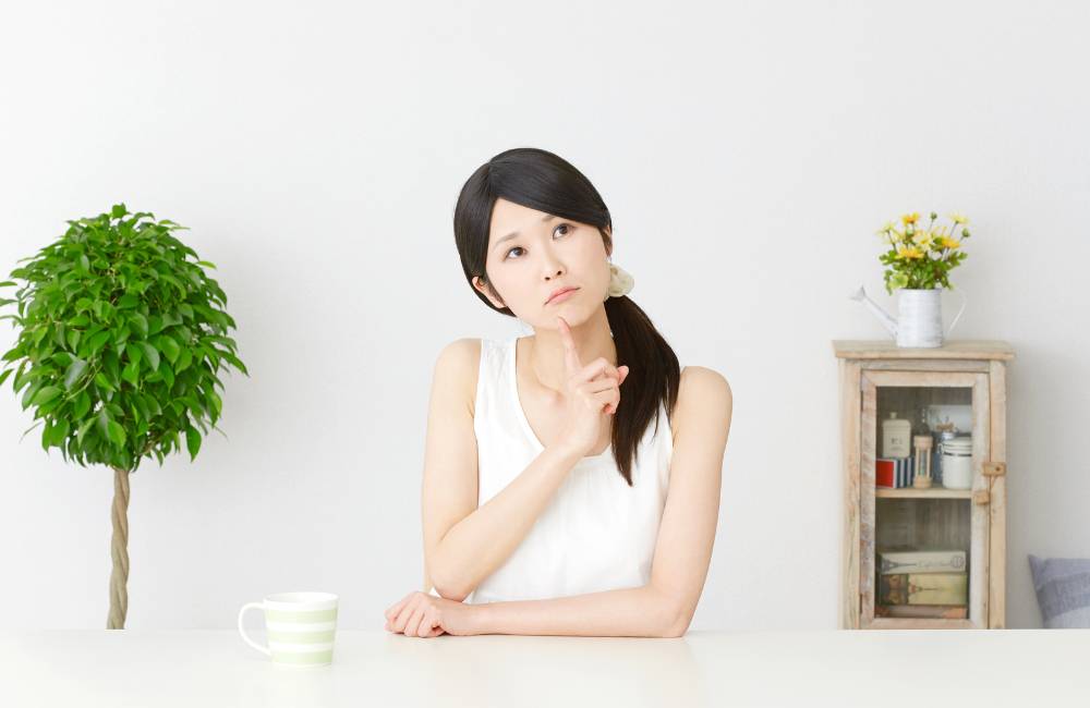 悩みを考える女性のイメージ写真