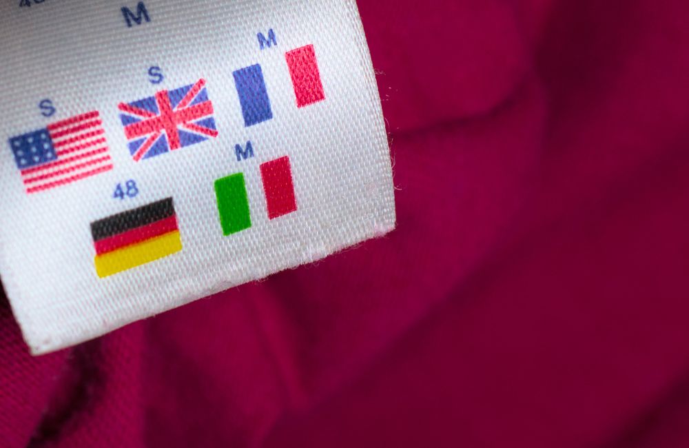 国やブランドによって異なるサイズ表記が記載された洋服のサイズタグ